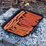 Tacka do grillowania - ale nie aluminowa tylko stalowa, pokryta taką żaroodporną emalią jak piekarniki. Rozpalamy ognisko, palimy do uzyskania odpowiedniej ilości żaru, kładziemy tackę i powoli bez przypalania się piecze oraz nic nam nie spadnie ani się nie przewróci. Tackę bardzo łatwo oczyścić chustką higieniczną albo mchem. Jest lekka i pakowna (315 gram, 34/24 cm). Nie potrzebujemy więc w ogóle węgla drzewnego na dodatek. Do tego jest wygodnym i obszernym talerzem. Oto najlepszy i ostateczny już pomysł na grillowanie plenerowe. Do grillowania najlepsze są tłuściejsze kabanosy - są cienkie więc podgrzewają się bardzo szybko.